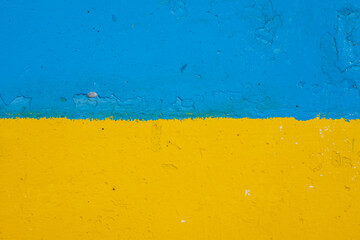 concrete wall painted in yellow and blue like Ukrainian flag, the country of victim of the aggressor