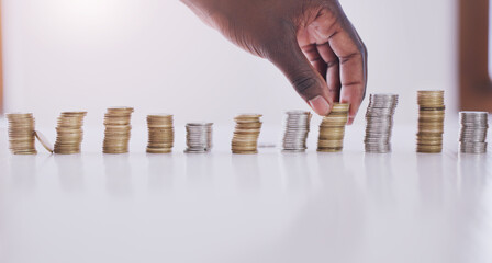 He saves every coin. Cropped shot of an unrecognizable businessman stacking up coins in his office during the day.