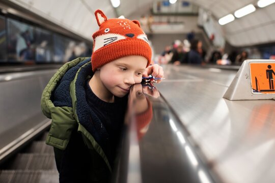 child playing on an escalator in an underground London station