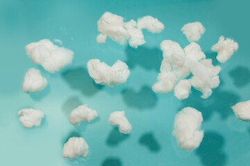 White cotton fake clouds on a pastel blue background.