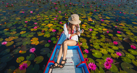 Top view traveler woman with camera on boat joy beautiful nature scenic landscape blooming red...