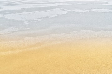 Fototapeta na wymiar Frozen lake (background) - resembling waves on a sandy beach