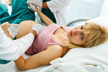Obraz na płótnie Canvas Woman giving birth in hospital with medical doctor team