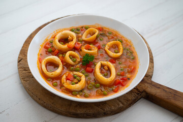 Squid stew, red pepper and peas. Spanish traditional tapas.