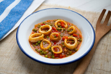 Squid stew, red pepper and peas. Spanish traditional tapas.