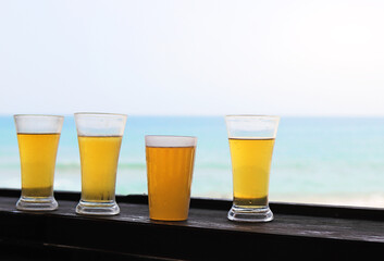 cold beer in glasses against the blue ocean and sky