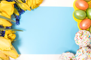Easter layout with tulips, cakes and eggs in the form of a frame with a place for text in the center, top view.