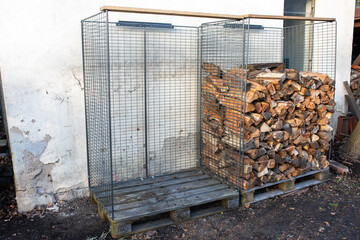 Zwei Gitterkörbe auf Europalette mit Brennholz ordentlich gestapelt