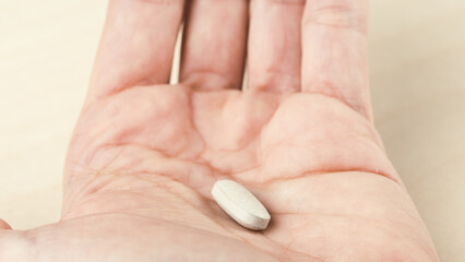 Close up of withe pills on hand