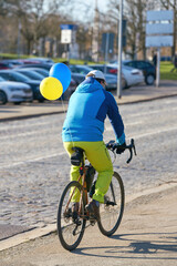 A cyclist wearing the colors of Ukraine on his way to a demonstration against the invasion of...