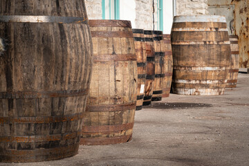 Old wooden barrels or casks at brewery backyard on a sunny day. Wine or beer oak vintage containers...