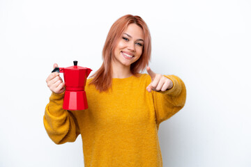 Young Russian girl holding coffee pot isolated on white background points finger at you with a confident expression