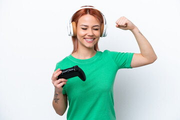Young Russian girl playing with a video game controller isolated on white background doing strong gesture