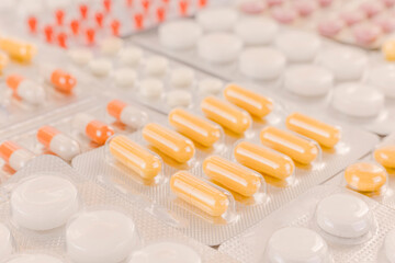 Background image: blister packs with medicines of different shapes and colors on the table