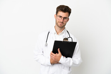 Young doctor caucasian man over isolated on white background wearing a doctor gown and holding a folder