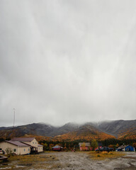 A gray autumn day at the KSS base in the Khibiny. Houses and cars against the backdrop of autumn mountains.