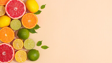 Creative copy space background with tropic summer citrus fruits and green natural leaves on beige theme. Flat lay