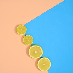Fresh citrus fruits composition of sliced lemons on pastel beige and blue background. Flat lay organic food minimal