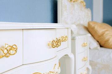 Interior in classic style. Luxurious white furniture with golden handles.