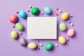 round frame multicolored Easter eggs with white blank paper on a brown background, close-up, space for text, blank for design, selective focus, tinted image