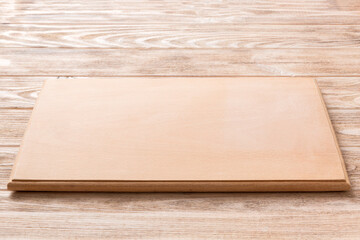 Perspective view of wooden cutting board on wooden background. Empty space for your design