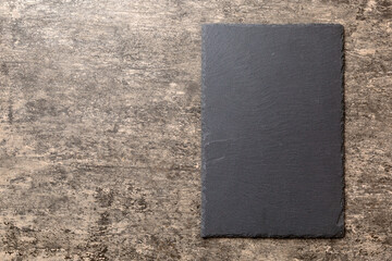 top view of empty black slate plate on cement background. Empty space for your design