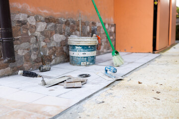 Renovation bonus, super bonus 110%, worker busy renovating the house, taking advantage of the state bonus. Various types of tools are arranged on a table or on the floor.