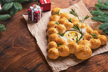 Bread buns Christmas tree with Roasted camembert cheese and rosemary on rustic background. Holiday...