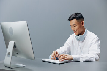 manager in a white shirt with headphones sits in the office Lifestyle work
