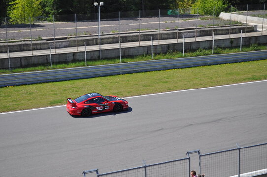 Red Sports American Muscle Car Rides On A Racing Circuit. Fast Driving On Asphalt Track.