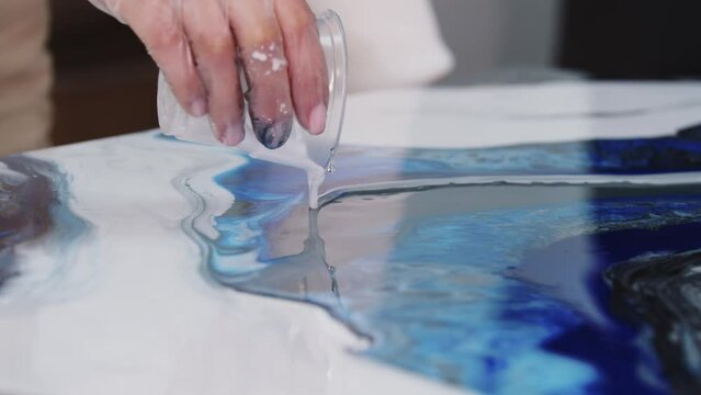 Pouring white epoxy on the painting