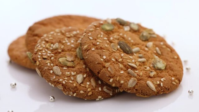 Eat oatmeal cookies. Stack of whole meal cookies on white background. Wheat fall on dietary cookies.