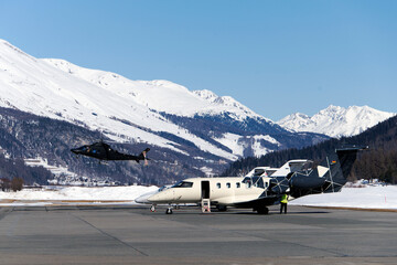 Private jets and a flying helicopter at Engadine St moritz airport