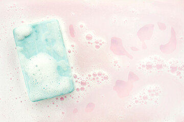 Soap bar and foam on pink background, top view. Mockup for design