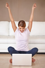 Done. Full length shot of an attractive young woman feeling cheerful and celebrating while using her laptop at home.