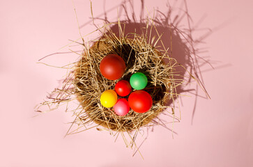 A nest with Easter eggs from a balloon with a large shadow on a pink background