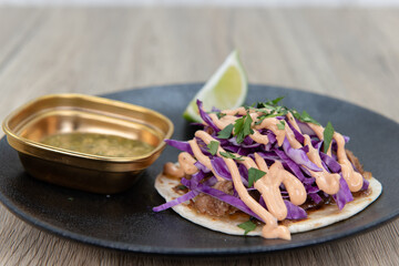 Tasty appetizer of seasoned pork taco with cilantro to eat before your meal