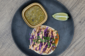 Overhead view of tasty appetizer of seasoned pork taco with cilantro to eat before your meal
