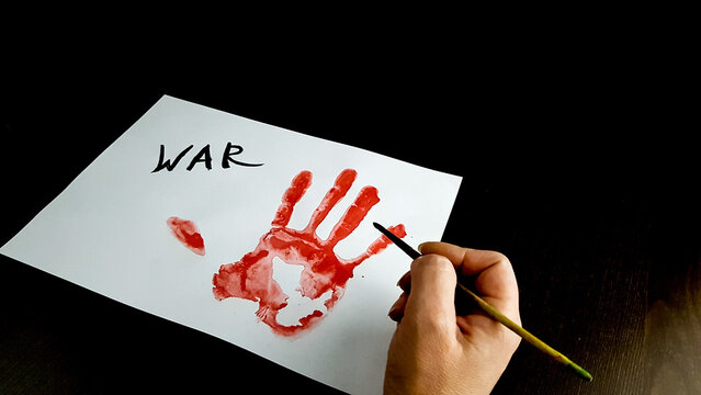 a person writes stop war on white paper. bloody hand palm print