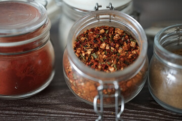 Hot spices in glass jars on a dark background