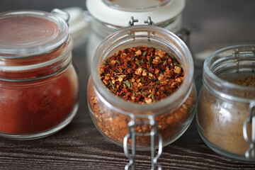 Hot spices in glass jars on a dark background