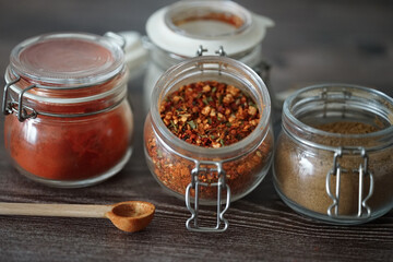 Hot spices in glass jars on a dark background