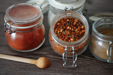 Hot spices in glass jars on a dark background