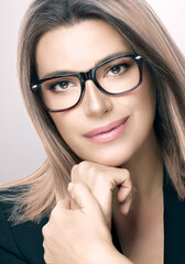 Attractive woman in spectacles and suit. Vertical beauty portrait on grey with copy space. women eyewear and clear vision concept