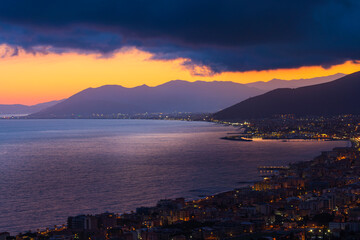 Scena panoramica con la vista sul mare di Borgio Verezzi, la sera, al tramonto. Pietra Ligure. Liguria. Viaggiare. Vacanze. Febbraio. Paesaggio marino. - obrazy, fototapety, plakaty
