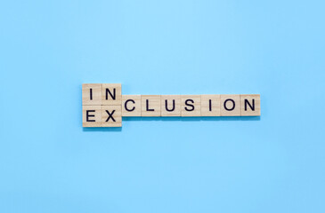 Word inclusion and exclusion on wooden blocks on blue background. Business concept D&I