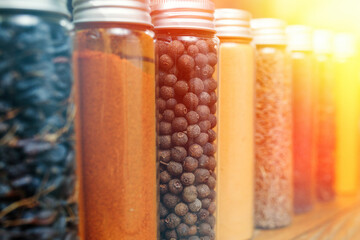 Spices and herbs of different colors in small jars. Selective soft focus.