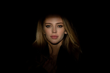 Naklejka premium Portrait of young attractive woman. Dramatic and sensual portrait of a beautiful girl isolated on a dark background in studio. Beauty close up face of beautiful pretty girl on black.