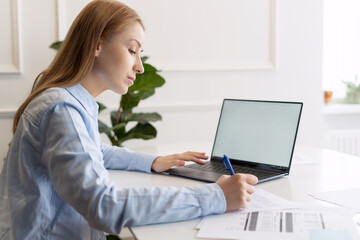 Beautiful woman with laptop and documents at home