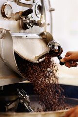 Fresh beans for the grind. Shot of coffee beans pouring into an industrial grinding machine.